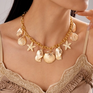 Close-up of golden shell and starfish charms on a thick link chain necklace