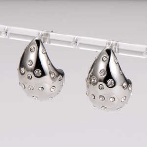 Elegant silver teardrop earrings with crystals displayed on a clear jewelry stand