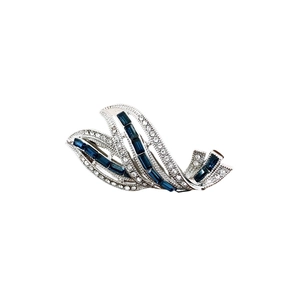 Elegant silver wavy brooch with pavé white crystals and blue baguette-cut gemstones