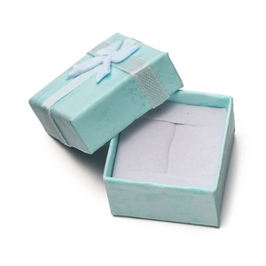 Close-up of a light blue jewelry gift box with a white ribbon bow and foam insert