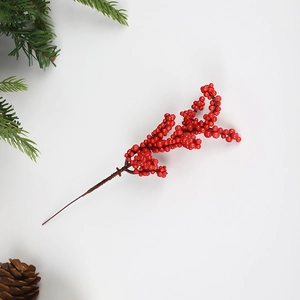 Vibrant red Christmas holly berries on dark branch with pine needle and pine cone accents