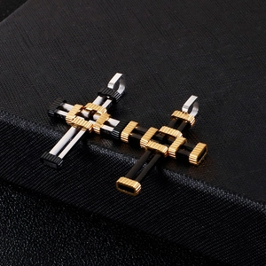 Detailed view of silver, gold and black punk layered cross pendants on textured background