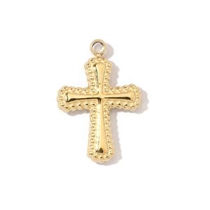 Detail of a vintage golden cross pendant with beaded edges and polished surface in titanium steel