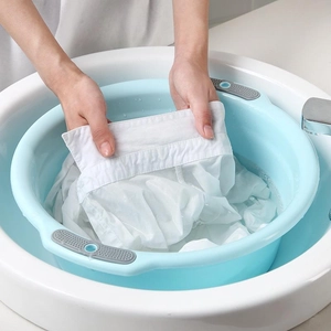Durable light blue plastic basin with gray non-slip handles in a clean bathroom sink