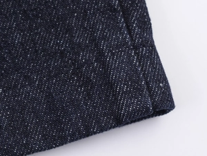 Detaillierte Makroansicht von dunkelblauem Denim mit Präzisionsnähten und Webstruktur