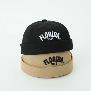 Detail of embroidered Florida 1845 logo on black and khaki cotton kids docker caps