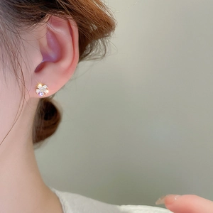 Gros plan de la boucle d'oreille fleur minimaliste avec dorure et zircons blancs