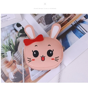 Detailed close-up of a pink bunny cross-body bag with 3D ears and a red bow on a table