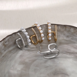 French vintage double-layered C-shaped pearl and zircon hoop earrings on a ceramic tray