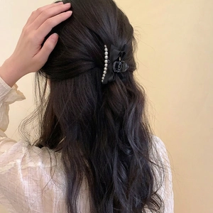 Elegant black ribbon bow hair claw clip with white pearls on model side view