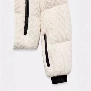 Women's white cable knit ski jacket featuring black zipper and sleek contrast cuffs