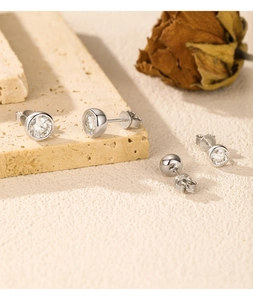 Detailed view of silver bubble earrings with 2 carat round moissanite on textured stone