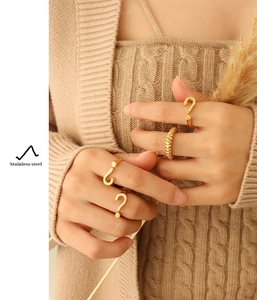 Golden question mark adjustable ring with textured twist design worn by a model