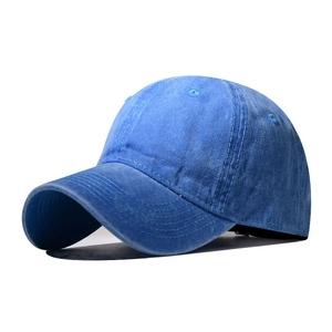 Side view of a washed blue denim baseball cap showing stitched eyelets and curved brim