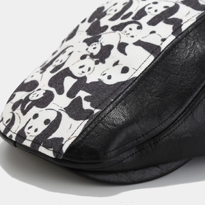Detail of panda canvas and black pebbled leather stitching on a vintage newsboy cap