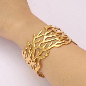 Detailed view of an 18K gold-plated titanium steel cuff featuring a hollow coral pattern