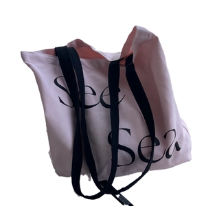 Pink canvas tote bag with See Sea letter print and black straps for casual daily use