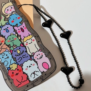 Close-up of heart-shaped beads on black wrist strap for monster pattern phone case