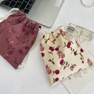 Floral corduroy drawstring pouches for skincare and makeup storage in a flat lay setting