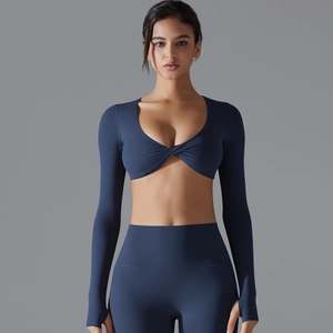 Dettaglio del crop top blu navy con scollo a V, asole per i pollici e leggings yoga abbinati