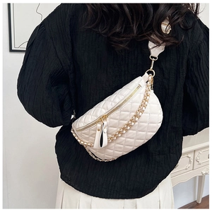 Detail of white quilted crossbody chest bag with golden chain strap on female model