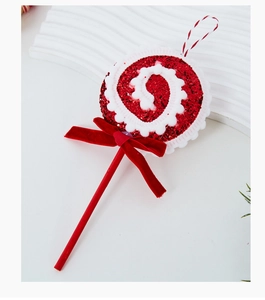 Close-up of red and white Christmas candy lollipop ornament with velvet bow and glitter