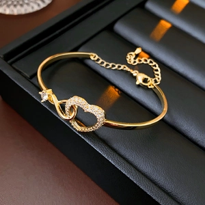 Detailed view of gold heart and infinity bracelet with sparkling zircon in a gift box