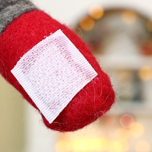 Detail of white square velcro strap on red Christmas curtain buckle for festive home decor