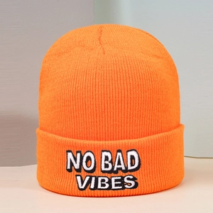 Detailed view of NO BAD VIBES black and white embroidery on orange knit beanie hat