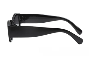 Side view detail of black thick frame sunglasses with glossy finish and wide temples