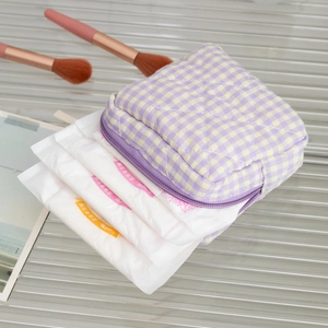 Detail view of purple plaid quilted makeup bag showing storage capacity with zipper close