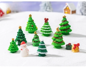 Macro view of assorted resin Christmas tree miniatures and a small snowman on snow base