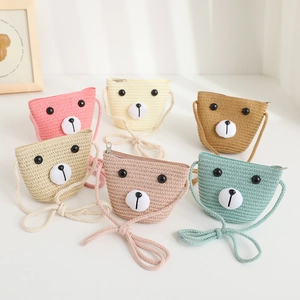 Detailed view of six colorful cartoon bear straw crossbody bags for kids on white surface
