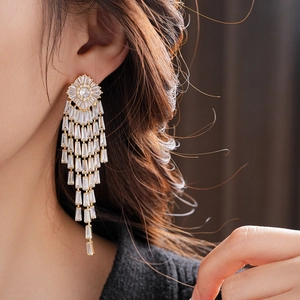 Detailed view of long gold tassel earrings with shimmering rectangular cubic zirconia stones