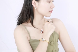 Detail view of a model wearing the golden daisy flower necklace and earring jewelry set
