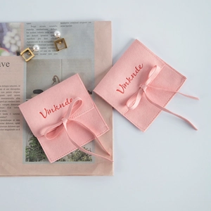 Dettaglio sacchetto gioielli in camoscio rosa, bustina velluto per anello collana con fiocco.