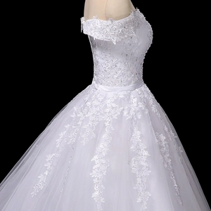 Close-up of floral lace embroidery with sequins and beads on a white bridal gown