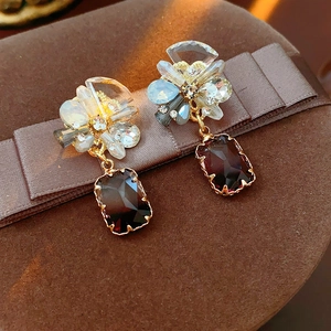 Detailed close-up of a vintage square earring with ruby red gemstone and crystals