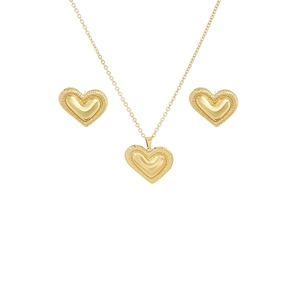 Detail of gold heart pendant necklace and earrings set with textured edges on white background