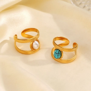 Double-layered gold rings with turquoise and white pearl on satin silk background