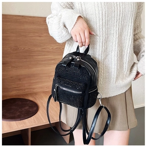 Detalle de una mini mochila negra con pedrería brillante y textura de cuero sintético PU