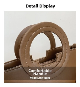 Detail of a brown bucket bag showing circular cutout handle and fine stitching craft