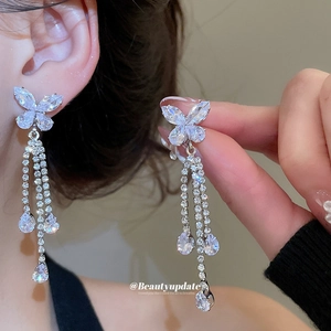 Elegant silver butterfly tassel earrings set with cubic zirconia on model