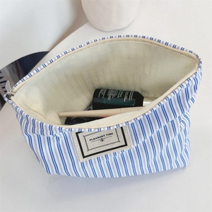 Detail view of the spacious blue striped canvas toiletry bag with zipper and inner lining