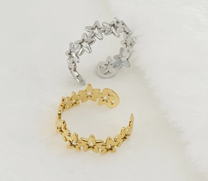 Detailed close-up of adjustable star-shaped steel rings in gold and silver finishes