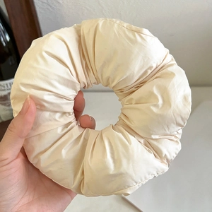 Macro detail of puffy cream oversized scrunchie showing soft quilted fabric and volume