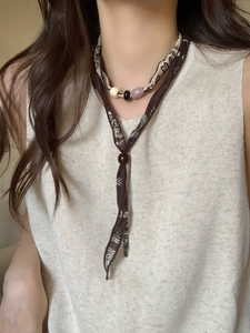Close-up of vintage Maillard fabric necklace with bohemian beads and acrylic accents