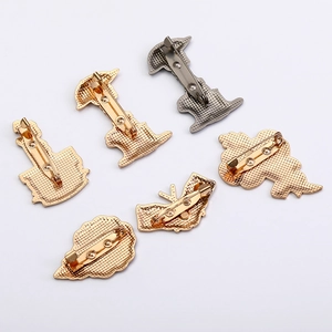 Detail view of the back of 6 metal flower pins with secure safety pin fasteners