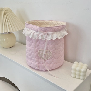 Pink quilted fabric storage basket with heart patterns and elegant white lace trim