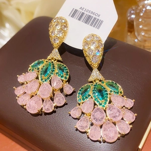 Macro shot of vintage style earrings with green marquise and pink teardrop gems